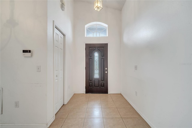 entryway featuring a towering ceiling and light tile patterned flooring