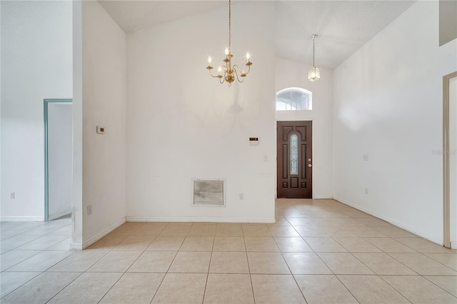 foyer featuring high vaulted ceiling, light tile patterned floors, and a notable chandelier