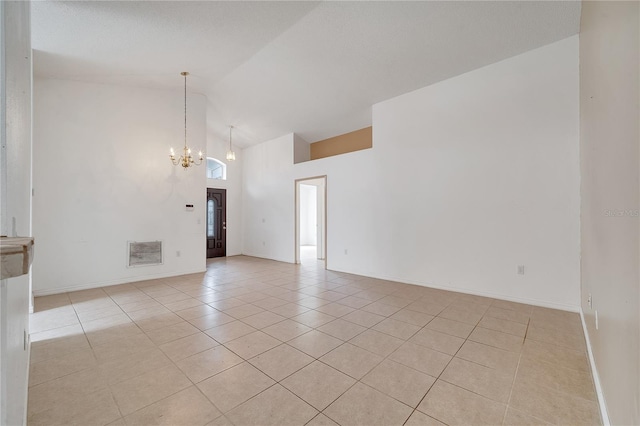 tiled spare room featuring high vaulted ceiling and an inviting chandelier