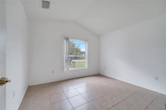 unfurnished room with vaulted ceiling and light tile patterned flooring