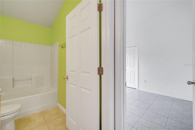 bathroom featuring toilet, a textured ceiling, tile patterned floors, and washtub / shower combination