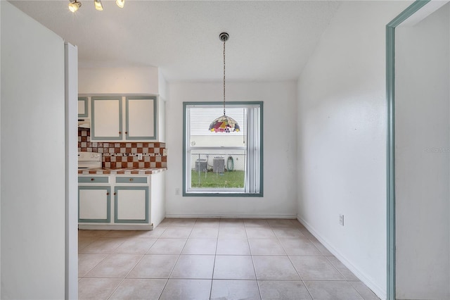 unfurnished dining area featuring light tile patterned floors and a textured ceiling