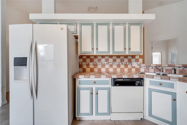 kitchen featuring sink, white cabinets, white appliances, decorative backsplash, and light tile patterned floors