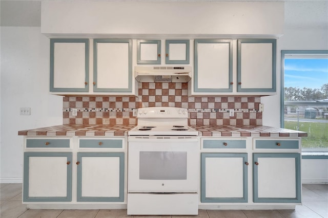 kitchen featuring tasteful backsplash, electric range, light tile patterned floors, and exhaust hood