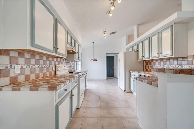 kitchen featuring white appliances, backsplash, lofted ceiling, a textured ceiling, and decorative light fixtures