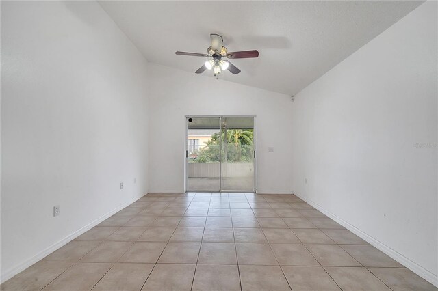 empty room with ceiling fan, light tile patterned floors, and lofted ceiling