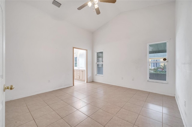 tiled spare room with high vaulted ceiling, ceiling fan, and a healthy amount of sunlight