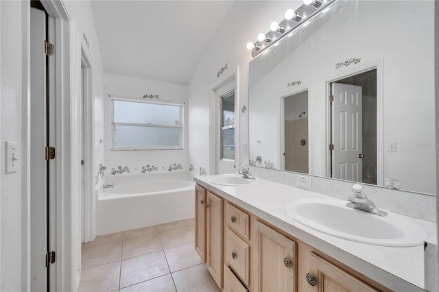 bathroom with tile patterned floors, vanity, vaulted ceiling, and a bathing tub