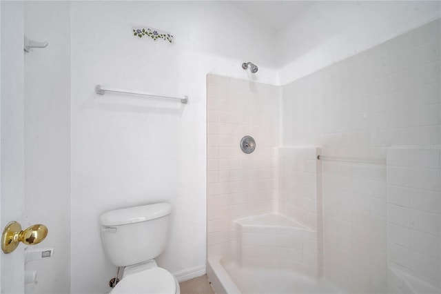 bathroom featuring toilet and a tile shower