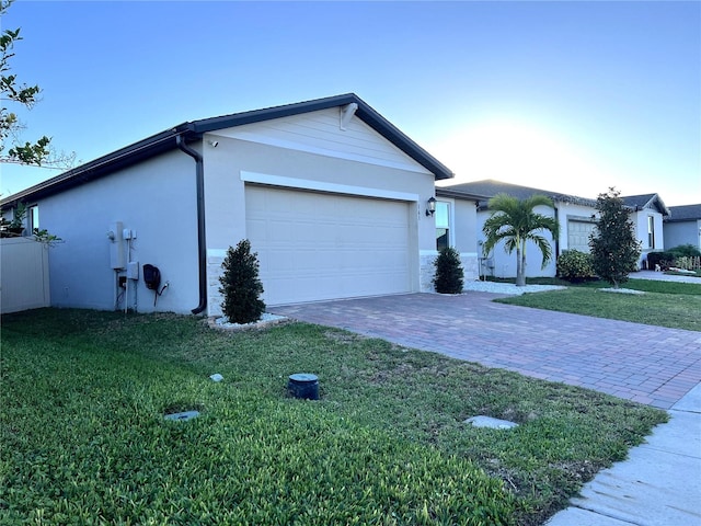 ranch-style home featuring a garage and a front lawn