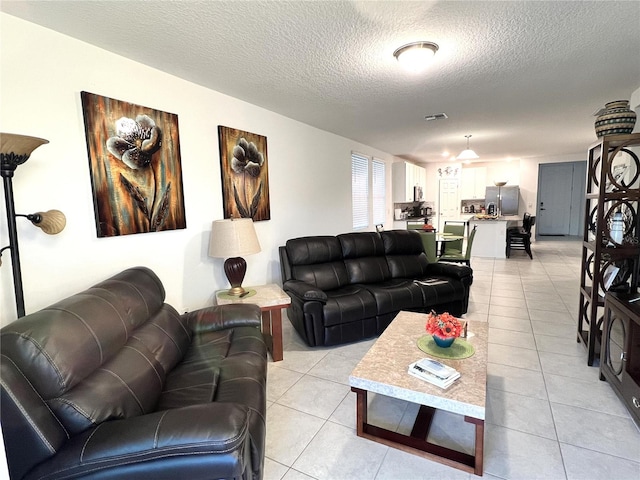 tiled living room featuring a textured ceiling