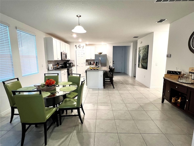 dining area with light tile patterned floors and a textured ceiling