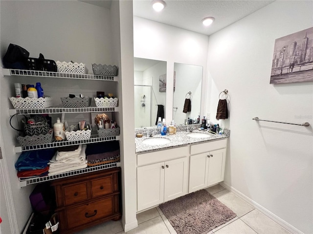 bathroom with tile patterned flooring, vanity, and walk in shower