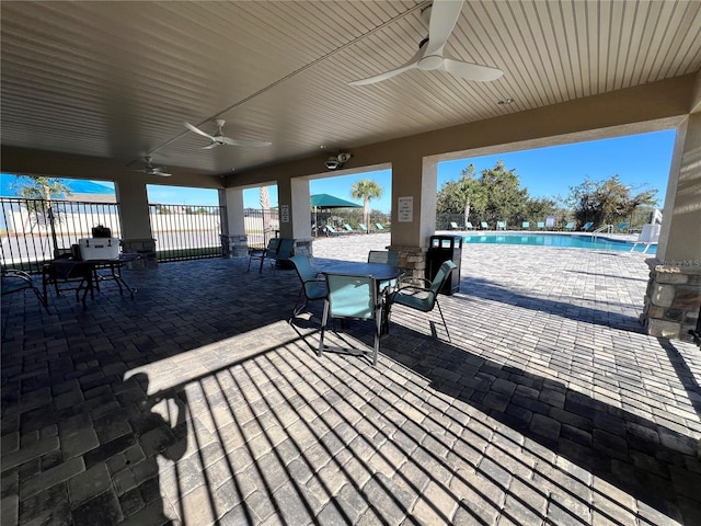 view of patio with ceiling fan and a community pool