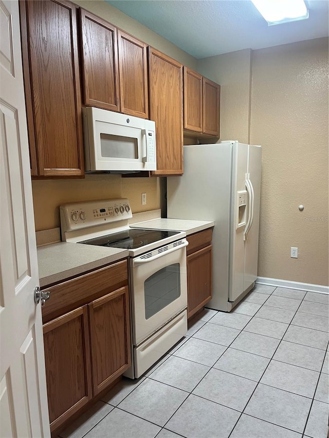 kitchen with light tile patterned floors and white appliances