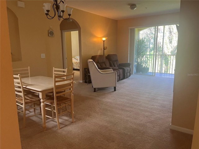 dining room with light colored carpet and an inviting chandelier