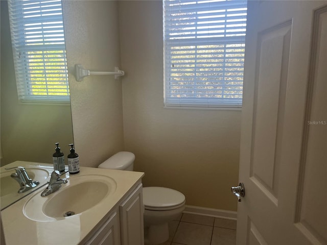 bathroom with toilet, vanity, and tile patterned floors