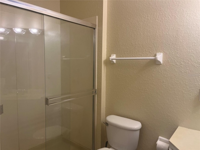 bathroom with toilet and an enclosed shower