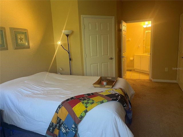 bedroom with light carpet and connected bathroom