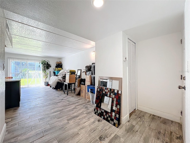 interior space with a textured ceiling and light wood-type flooring