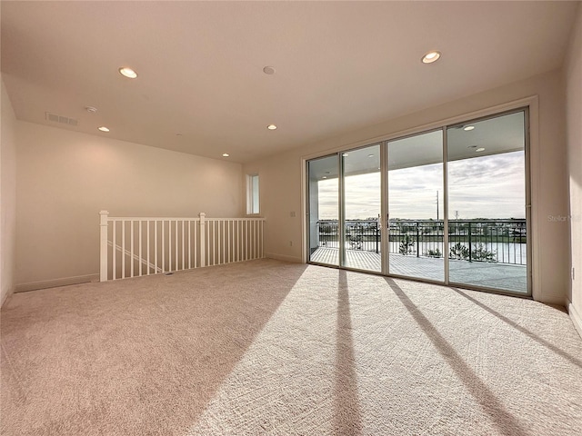 carpeted spare room with a water view