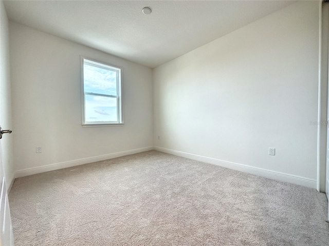 unfurnished room featuring light carpet