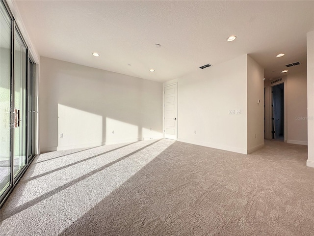 unfurnished room featuring carpet flooring and a textured ceiling