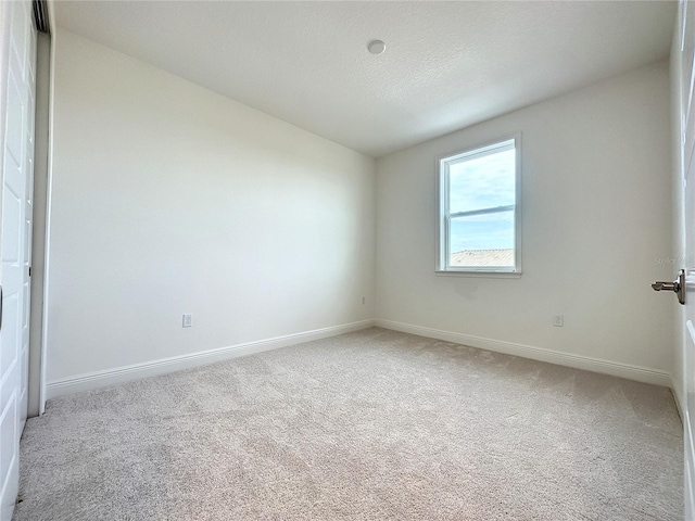 carpeted spare room with a textured ceiling