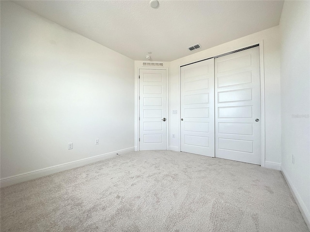 unfurnished bedroom featuring carpet flooring and a closet