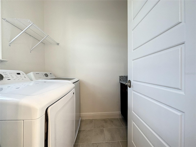 laundry area featuring light tile patterned flooring and washing machine and dryer