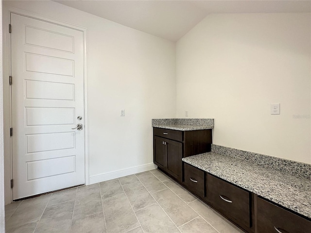 interior space featuring tile patterned floors and lofted ceiling