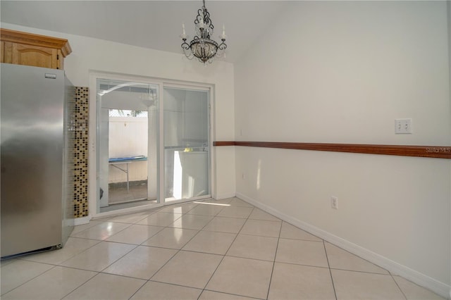 unfurnished dining area featuring light tile patterned flooring, a chandelier, and lofted ceiling