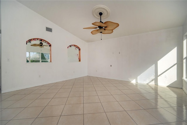 tiled spare room featuring vaulted ceiling