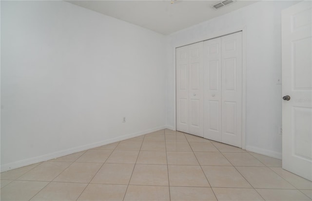 unfurnished bedroom with a closet and light tile patterned floors