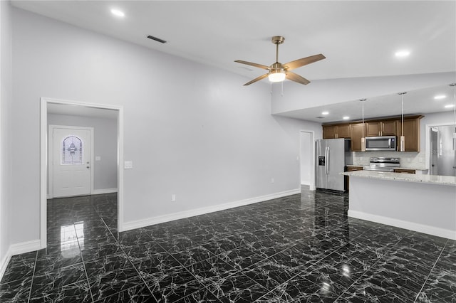 unfurnished living room with ceiling fan and high vaulted ceiling