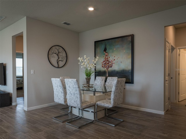 dining area featuring a textured ceiling and dark wood-type flooring