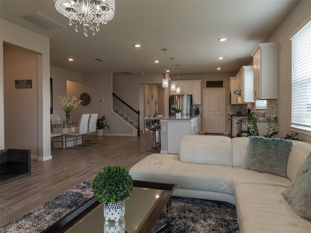 living room with a chandelier and dark wood-type flooring