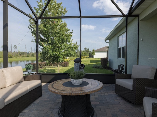 view of patio / terrace with a lanai, an outdoor living space, and a water view