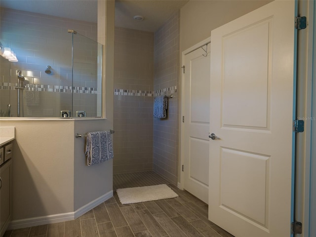 bathroom with vanity and a tile shower