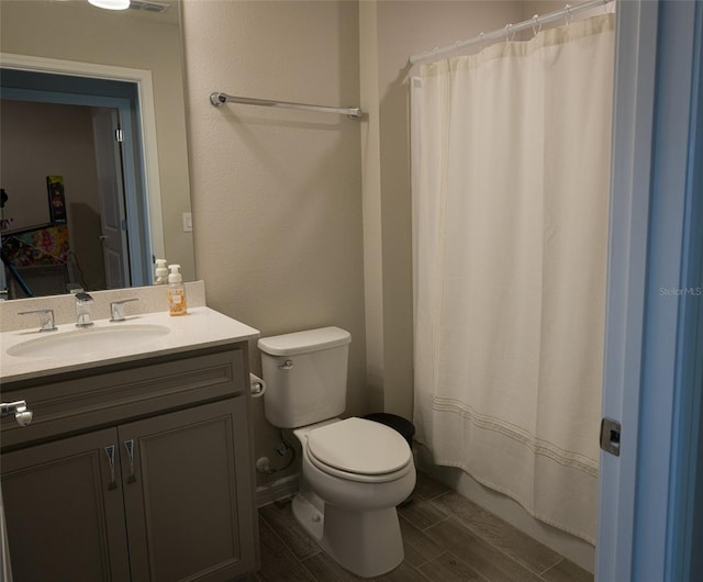 bathroom featuring a shower with shower curtain, vanity, and toilet