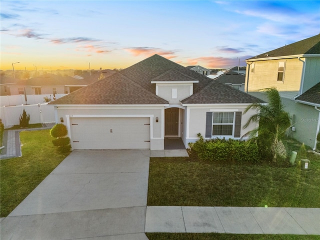 view of front of house featuring a garage and a yard