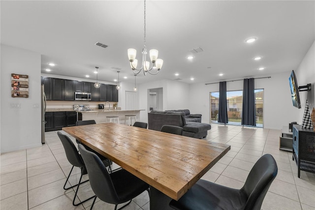 dining room with light tile patterned floors and an inviting chandelier