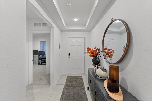 tiled foyer entrance featuring a raised ceiling