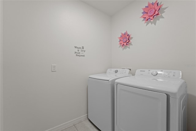 laundry area with washer and clothes dryer and light tile patterned floors