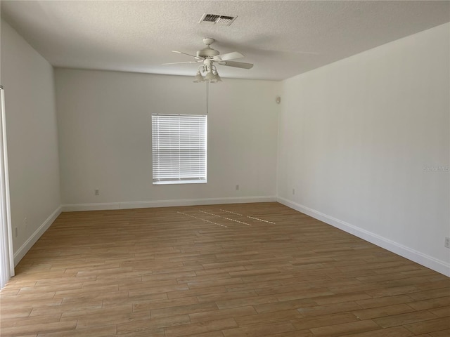 unfurnished room featuring visible vents, a textured ceiling, light wood-style floors, baseboards, and ceiling fan