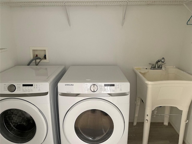 laundry room with laundry area, independent washer and dryer, and wood finished floors