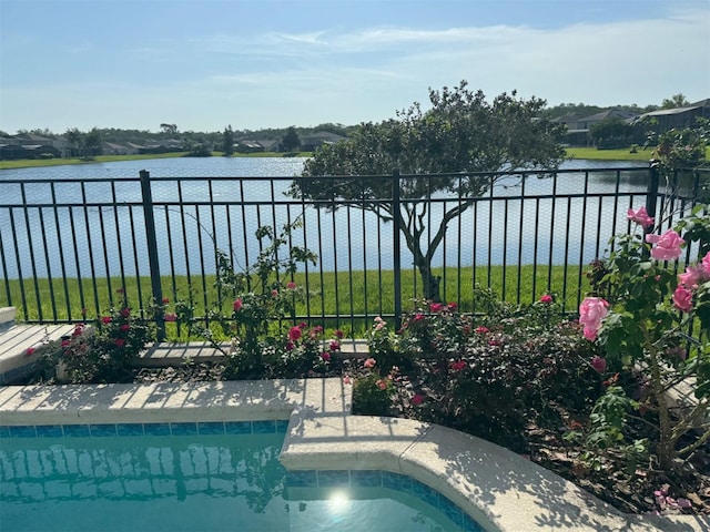 view of pool with fence and a water view