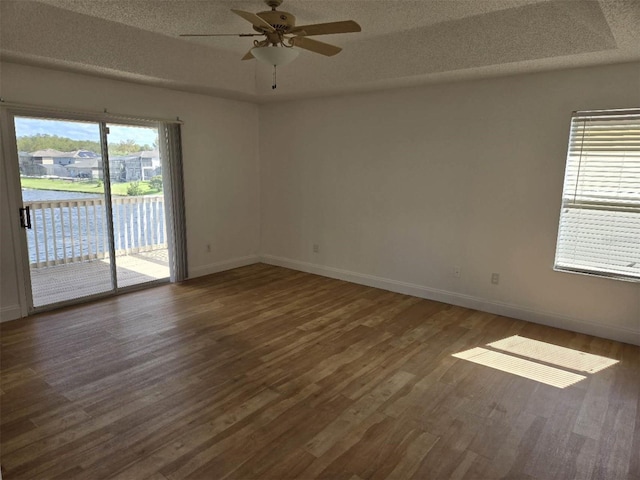 empty room featuring ceiling fan, a textured ceiling, and wood finished floors