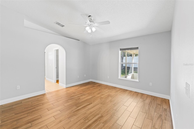 empty room with ceiling fan, light hardwood / wood-style floors, and a textured ceiling