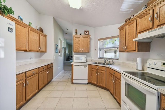 kitchen featuring sink, light tile patterned floors, and white appliances